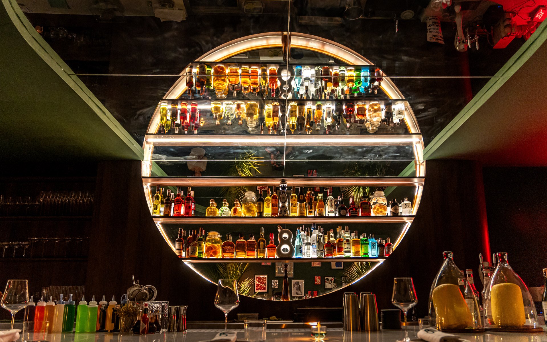 The illuminated circular back bar at Bisou, a modern French cocktail bar in Cherngtalay, Phuket