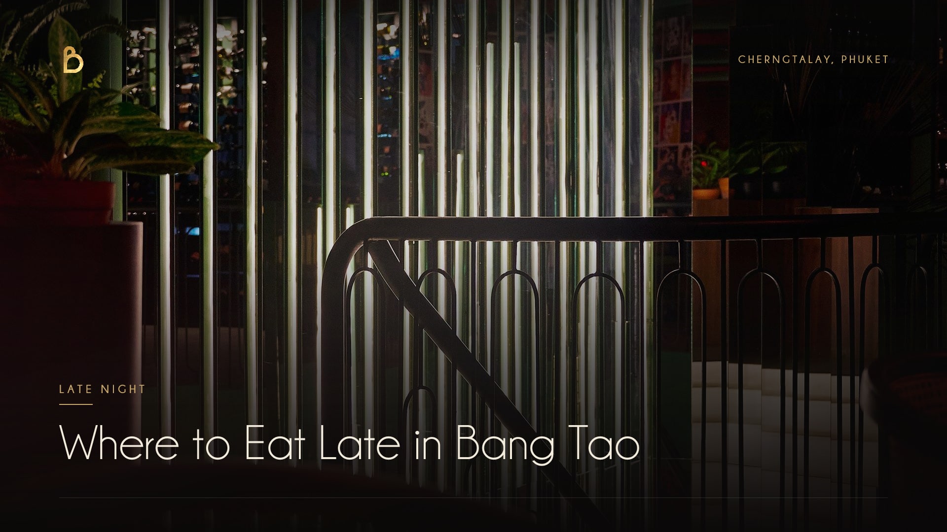 The lit facade of Bisou, a modern French restaurant on Bandon-Cherngtalay Road near Bang Tao Beach, open late for dinner and cocktails